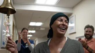 Smiling patient ringing a bell