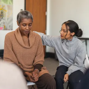 woman comforting another woman in a group session