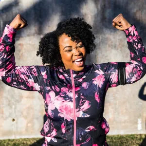 A Woman Triumphantly Flexes Her Arms After a Run in the Park
