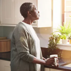 A Woman Stairs Out Her Kitchen Window, Deep in Thought.