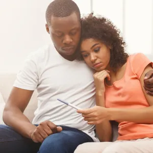 A Couple Embraces While Waiting for the Results of a Home Pregnancy Test.