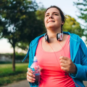 A Woman Jogging in a Park Carrying a  Water Bottle