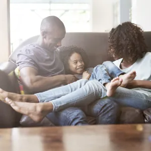An African American family hangs out on the couch at home.