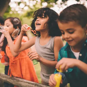 A group happy children blowing bubbles during the summer.