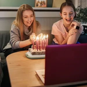 A family celebrating a birthday over video chat.