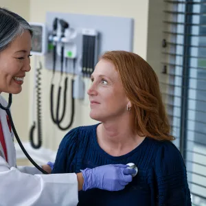 Doctor checking heart beat.