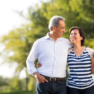 A mature couple walking while holding each other