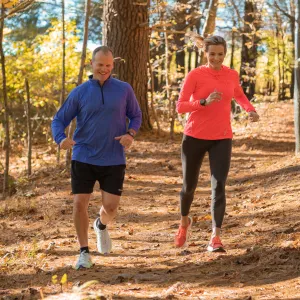 A Middle Aged Couple Goes For a Jog Through a Wooded Trail.