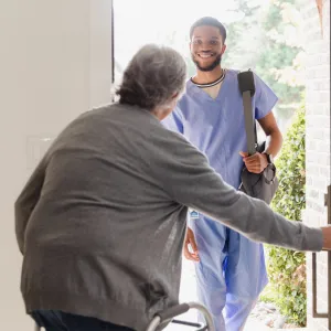A Patient Opens Their Front Door to Allow a Therapist in Their Home