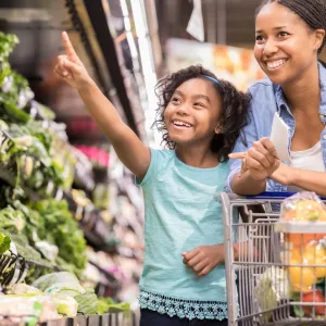 A mother and daughter shop for nutrient-rich vegetables at the supermarket.