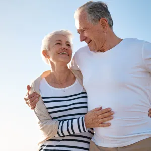 A couple walks on the beach after a successful hernia surgery.
