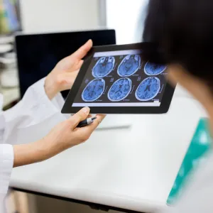 A hospital care team reviews scans of a patient's brain