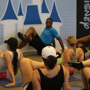 A group of runnings foam rolling with an AdventHealth expert at a runDisney race.