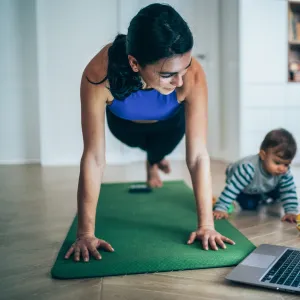 A mom exercising at home with her baby.