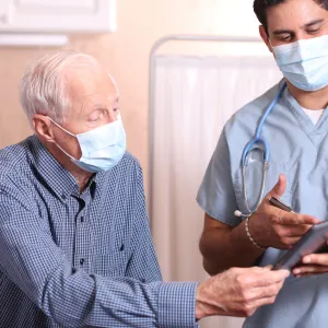 A man having a safe visit with his doctor. 