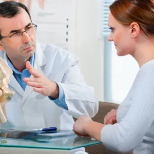 A woman discusses treatment options with her spine doctor.