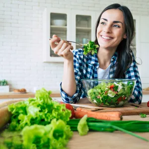 A woman eating a healthy, homemade salad.