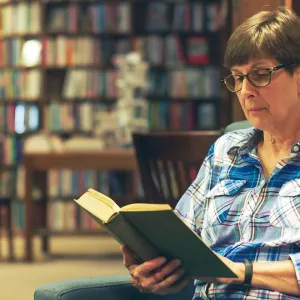 Woman reading book in library