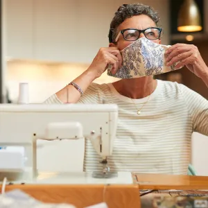 A woman sewing a custom face mask.