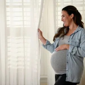 Pregnant woman standing near window