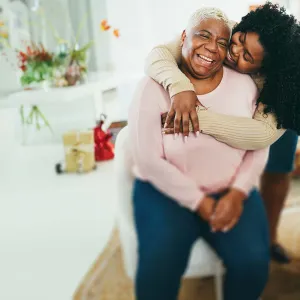 Seated mother embraced by daughter