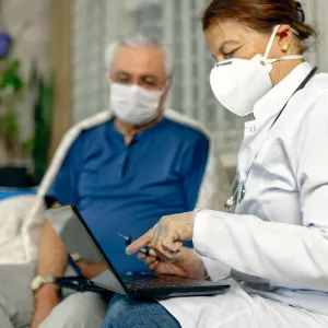 An older man being seen by a doctor.