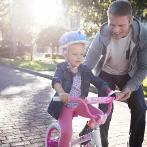 Dad teaching his daughter to ride her bike.