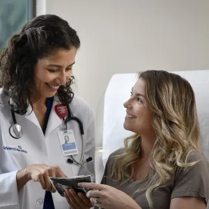 Young Woman talking to her doctor in a patient room.