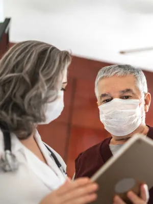 Mature female doctor talking to a male patient