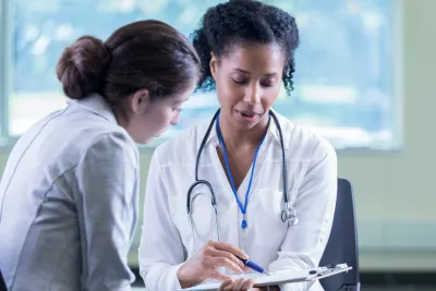 A Physician Goes Over A Chart With Her Patient