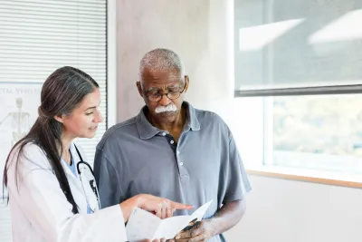 A Doctor Goes Over a Brochure with Her Senior Patient