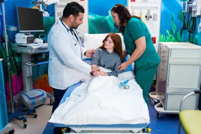 Doctor and nurse standing beside patient