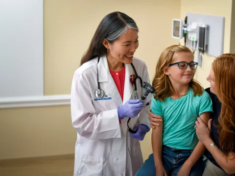 A Physician Smiles at Her Patient's Mother as They Wrap up Her Doctor's Visit
