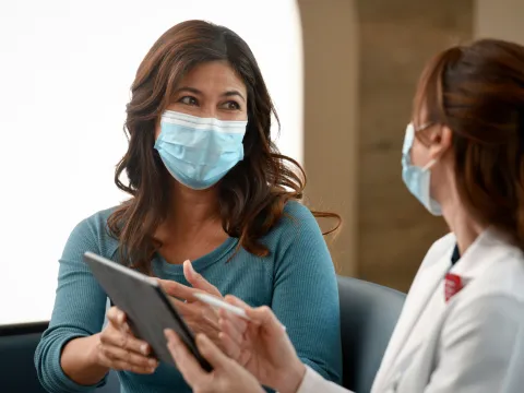 A Woman Consults With Her Doctor with a Tablet.
