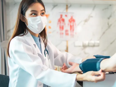A Doctor Takes a Patient's Blood Pressure with a Blood Pressure Cuff