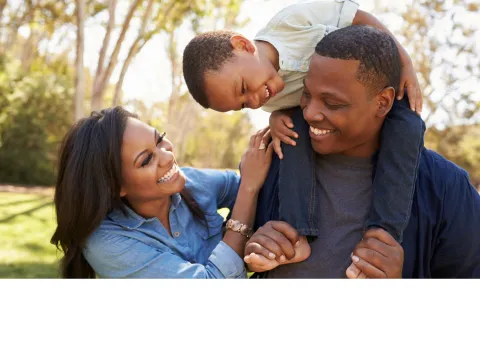 A Family Laughs Together in the Park.
