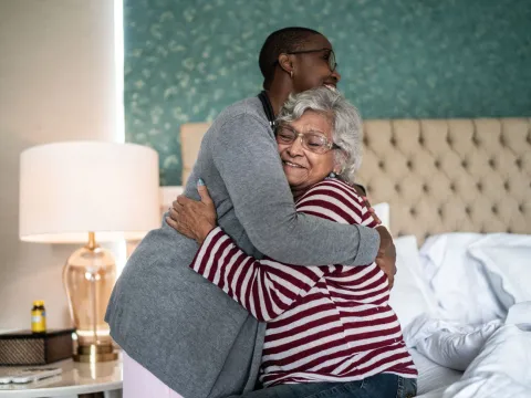 A Nurse Embraces Her Elderly Patient