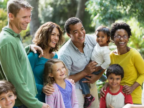 A Blended Family Walks Through a Park with a Guide.