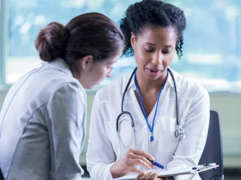 A Physician Goes Over A Chart With Her Patient