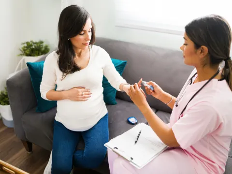A Nurse Checks a Pregnant Patient's Blood Sugar at Her Home.