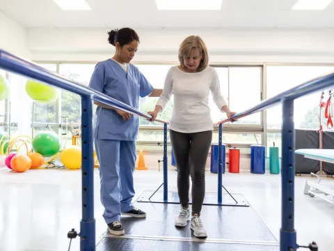 A Female Patient Attends Physical Therapy for Walking with a Therapist
