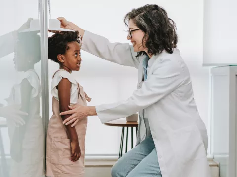 A Physician Checks Her Pediatric Patient's Height