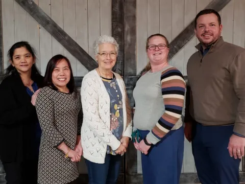 A group of co-workers standing next to each other.