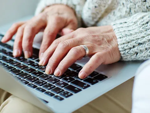 Hands typing on a laptop
