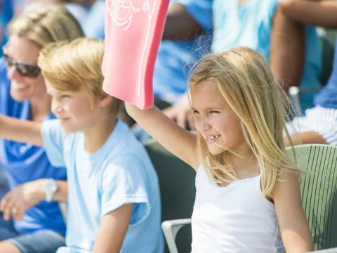 A family cheers on their favorite team at a sporting event.