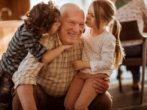 A grandfather plays with his grandchildren.
