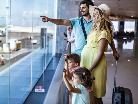 A family watches planes at the airport together.