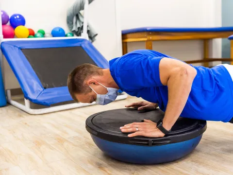 A man on a medicine ball balancer