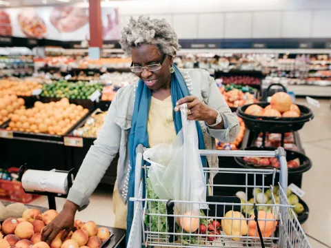 Older woman shopping for produce at the grocery store