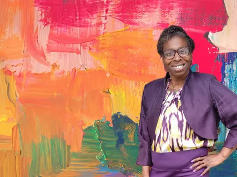 Denise Giles in front of a painterly background.